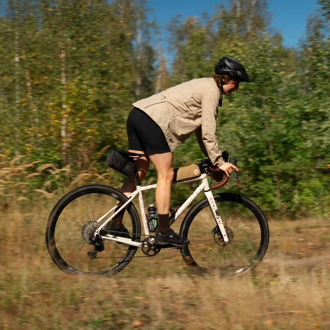 A woman in action on her bike, cycling through the woods