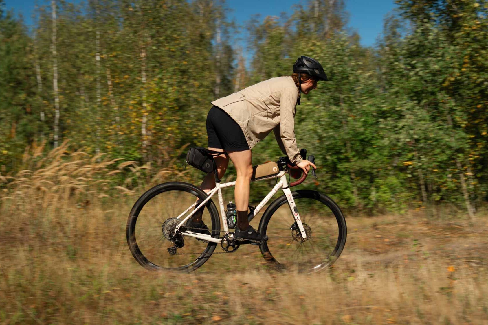 A woman in action on her bike, cycling through the woods
