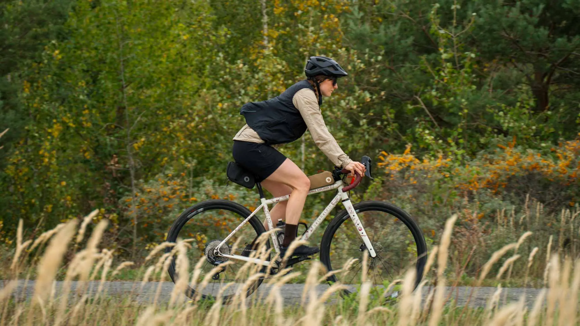 A woman on veloheld.iconX is cycling fast along a gravel path