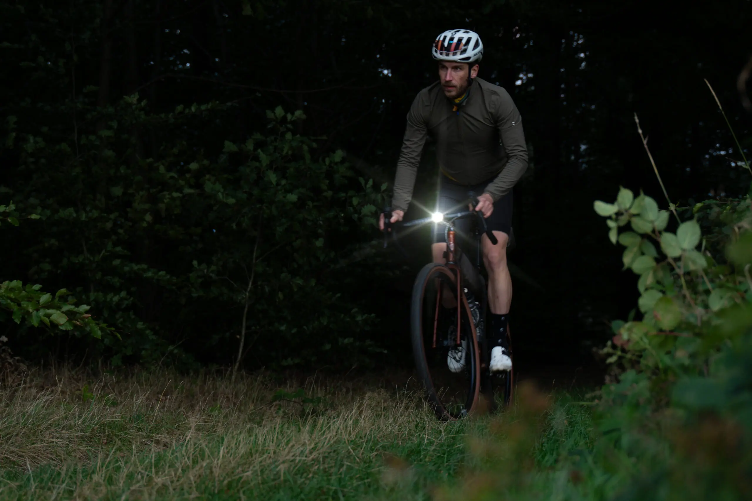 Gravel bike by veldheld in the forest with bright light on the handlebars