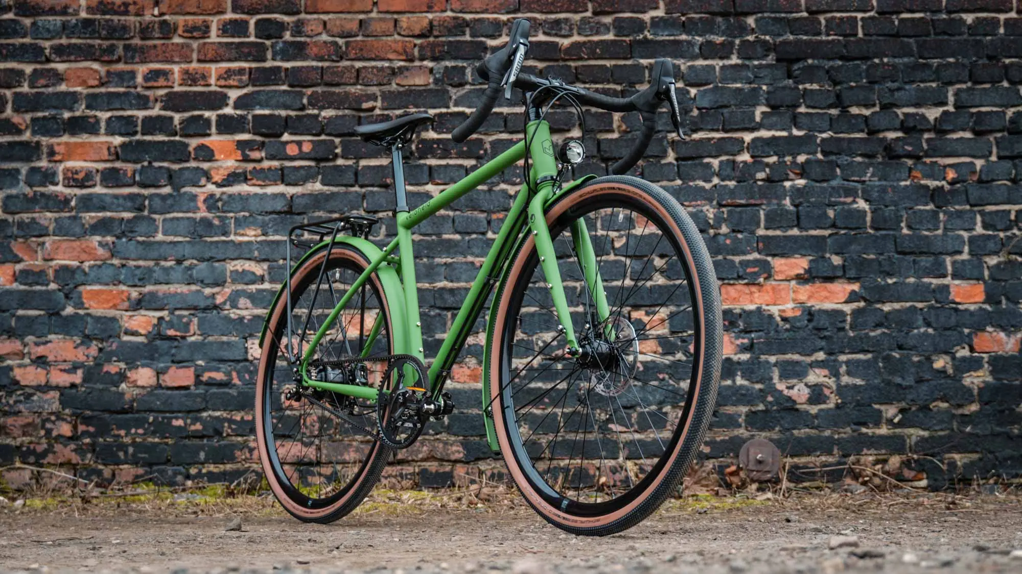 veloheld.alleyX Tourist in grass green as a complete bike in front of a brick wall