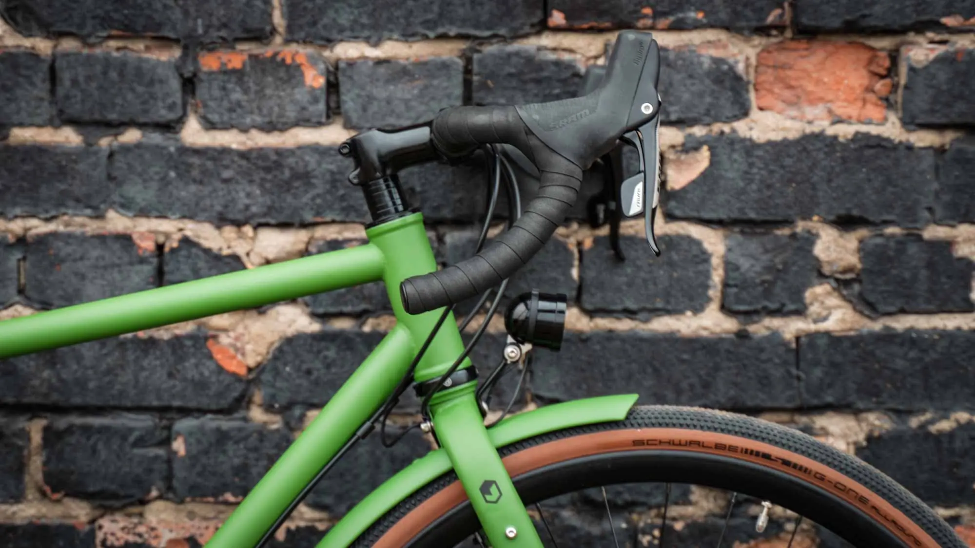 veloheld.alleyX Tourist in grass green, cockpit detail in front of brick wall