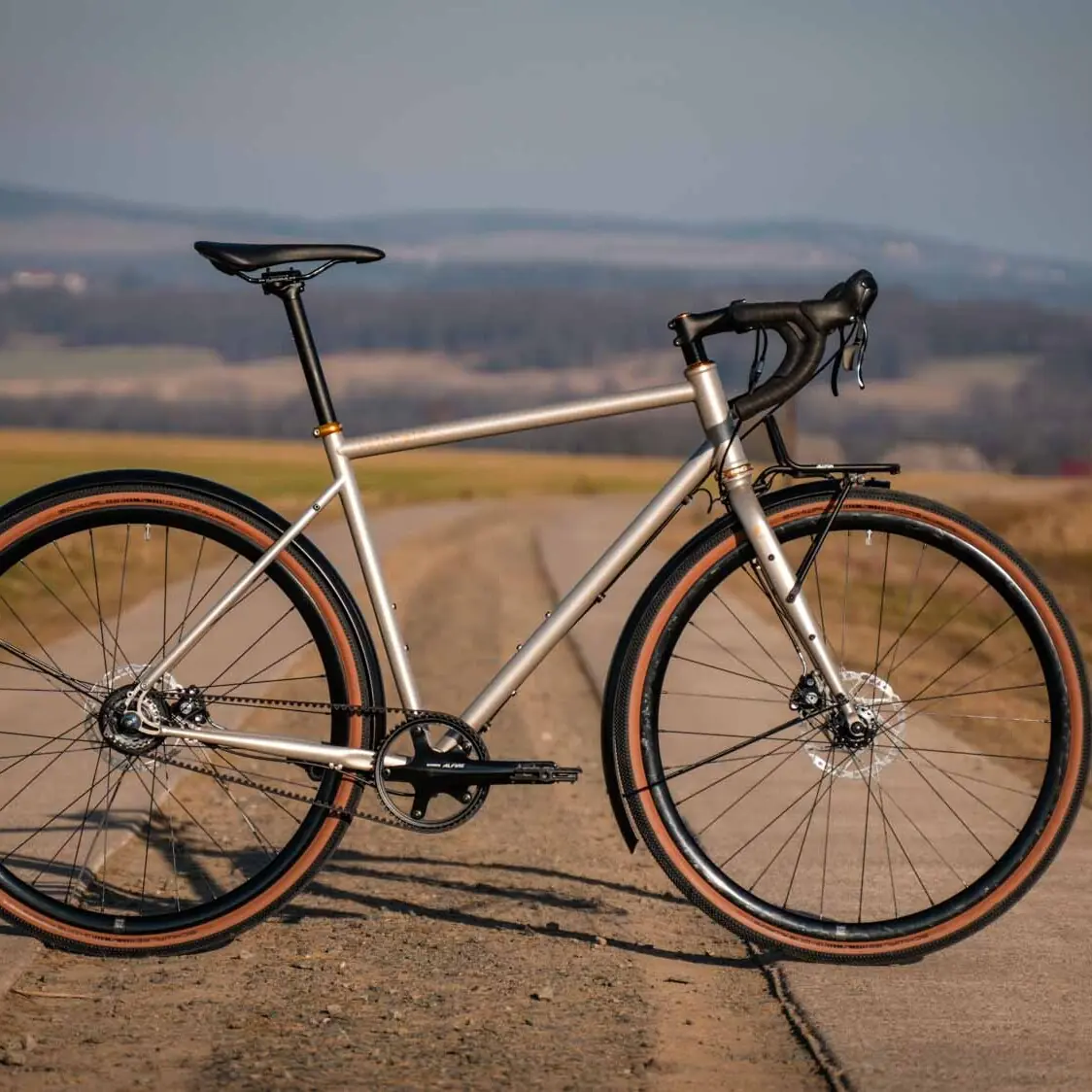 veloheld alleyX gravel bike in Roman bronze on an open country road, side view in the evening light