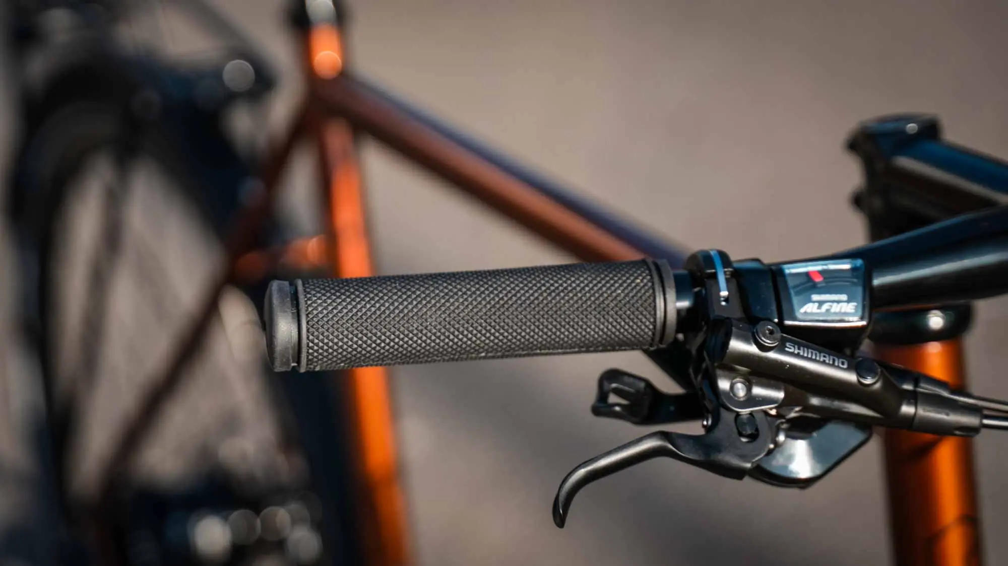 Close-up of the cockpit of the veloheld lane urban bike with handle, brake lever, and gear shift unit in transparent copper