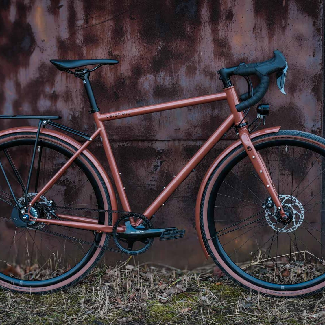 veloheld.alleyX Tourist in perlkupfer in der Komplettansicht draußen gegen eine Wand gelehnt