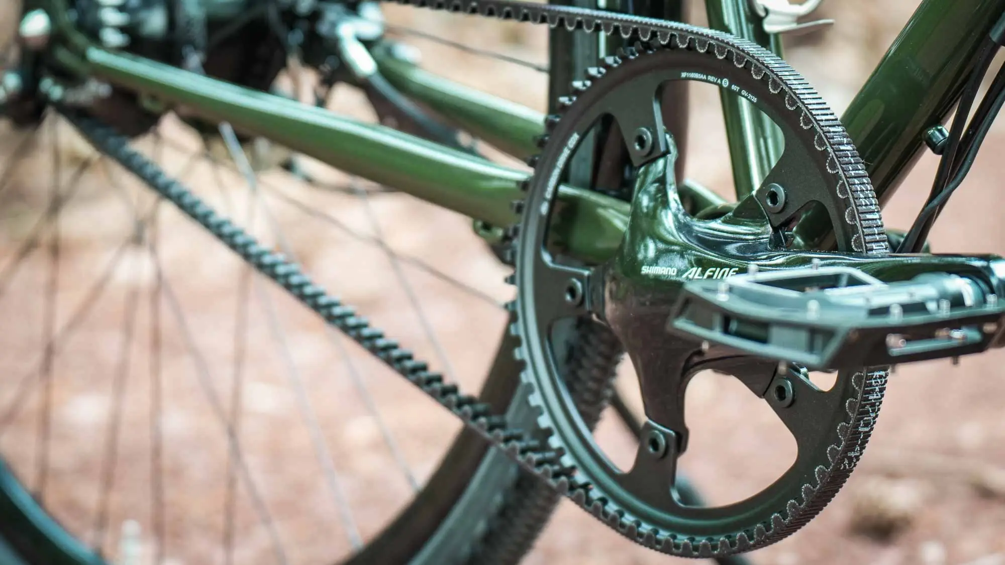 Close-up of crank, pedal and Gates Carbon Drive belt drive on the green veloheld.alleyX with Rohloff hub gears.